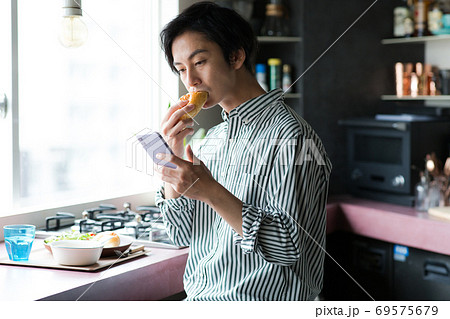 キッチンで朝食を食べる男性 69575679