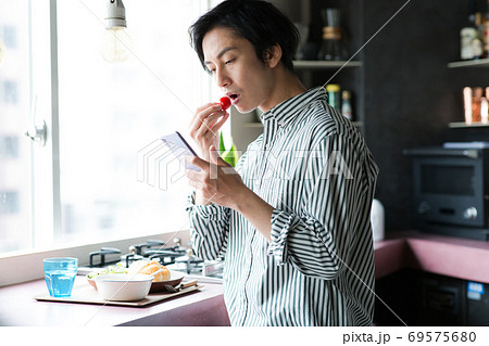キッチンで朝食を食べる男性 69575680