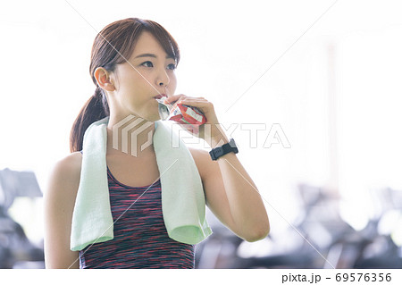 スポーツジムで栄養補給をする女性 69576356
