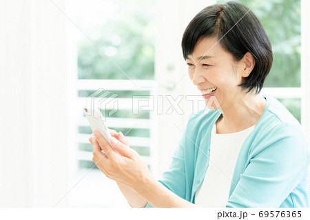 スマホでビデオ通話をするミドル女性 スマホでビデオ通話をするミドル女性 69576365