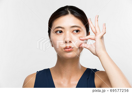 頬をつまむ女性 69577256