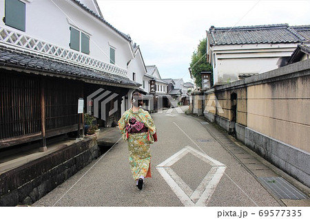 風情ある古都の街並みを歩く着物の日本人女性の後ろ姿の写真素材