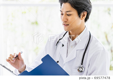 明るい室内で問診する男性医師 明るい室内で問診する男性医師 69577478