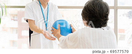 リハビリをするシニア女性と理学療法士 リハビリをするシニア女性と理学療法士 69577570