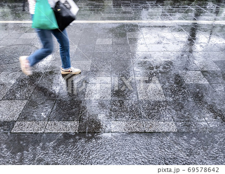 大雨の降る街路を走る人 69578642
