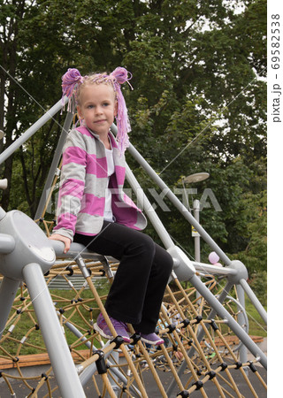 Portrait of a girl on a street Playground. A beautiful girl looks at the camera. 69582538