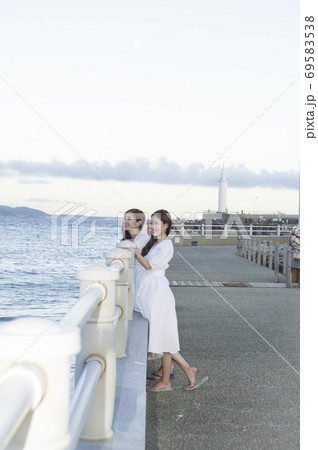 海沿いの遊歩道を散策する二人の女性 69583538