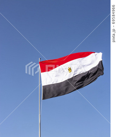 National flag of Egypt flying high against the blue sky National flag of Egypt flying high against the blue sky 69584966