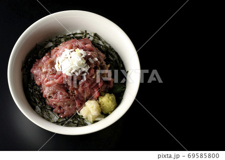 ガリとワサビも一緒に乗っている刻み海苔を敷いた山盛り鮪のすき身丼（黒背景、俯瞰） 69585800