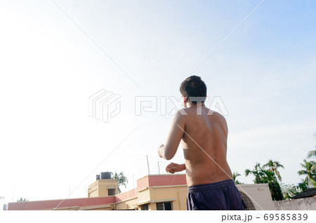 A man flying Kite in the sky. Kites flying picture with blue sky and white clouds. Photography in the eve of Vishwakarma Puja in Kolkata. 69585839
