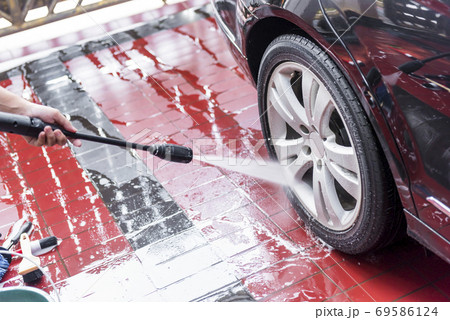 Man cleaning the car wheels 69586124