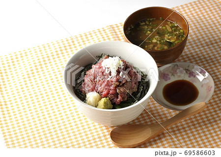 ランチョンマット上の刻み海苔を敷いた山盛り鮪のすき身丼とお味噌汁とお醤油、木製スプーン 69586603