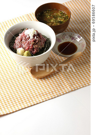 ランチョンマット上の刻み海苔を敷いた山盛り鮪のすき身丼とお味噌汁とお醤油、木製スプーン ランチョンマット上の刻み海苔を敷いた山盛り鮪のすき身丼とお味噌汁とお醤油、木製スプーン 69586607