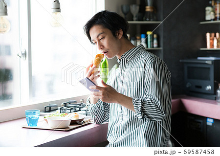 キッチンで朝食を食べる男性の写真素材 69587458 Pixta
