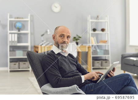 Mature man with tablet computer working online, chatting with family, consulting doctor or watching webinar at home 69587695