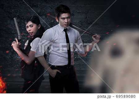 Asian people in police vest standing with a baseball bat and gun Asian people in police vest standing with a baseball bat and gun 69589080