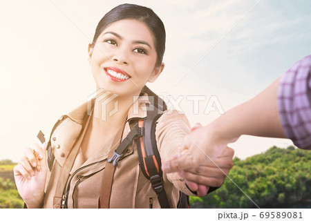 Asian woman with a backpack holding her boyfriend's hand while traveling Asian woman with a backpack holding her boyfriend's hand while traveling 69589081