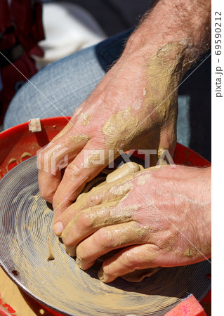 Creating clay jar by hands with potter wheel Creating clay jar by hands with potter wheel 69590212