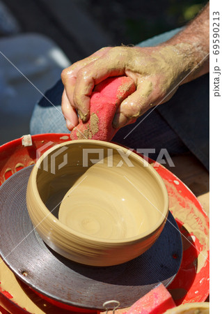Creating clay jar by hands with potter wheel Creating clay jar by hands with potter wheel 69590213