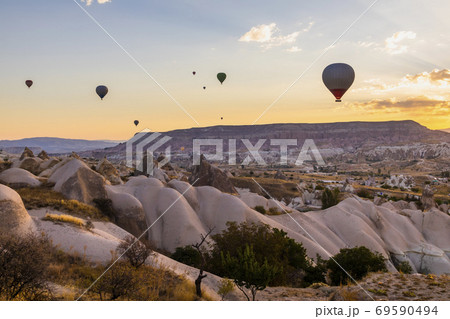 Hot air balloons flying over a volcanic landscape at Cappadocia, Turkey 69590494