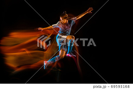 Football or soccer player on black background in mixed light, fire shadows Football or soccer player on black background in mixed light, fire shadows 69593168