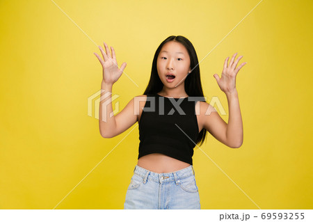 Portrait of young asian girl isolated on yellow studio background 69593255