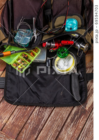 Different fishing tacles with rod and reels on wooden brown background. Different fishing tacles with rod and reels on wooden brown background. 69594703