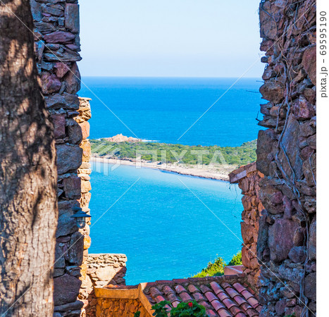 Capo Coda Cavallo shore seen through a rustic wall Capo Coda Cavallo shore seen through a rustic wall 69595190