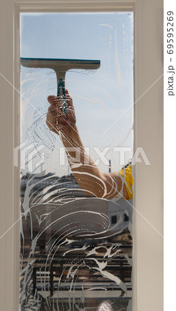a man washes windows on a sunny day a man washes windows on a sunny day 69595269