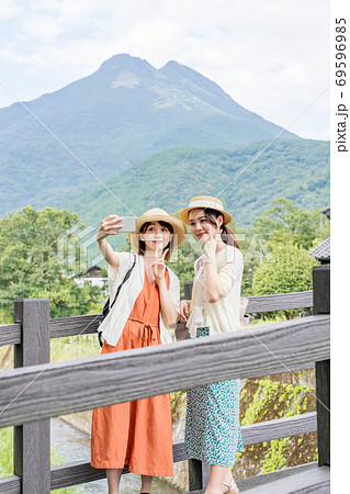 女子旅で由布岳を背景にスマホで撮影する若い女性と友達 【9月】 女子旅で由布岳を背景にスマホで撮影する若い女性と友達 【9月】 69596985