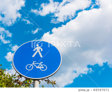 Pedestrian and bike sign under a cloudy sky 69597071