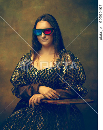 Young woman as Mona Lisa on dark background. Retro style, comparison of eras concept. Young woman as Mona Lisa on dark background. Retro style, comparison of eras concept. 69599407