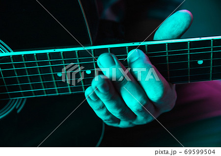 Close up of guitarist hand playing guitar, copyspace, macro shot Close up of guitarist hand playing guitar, copyspace, macro shot 69599504