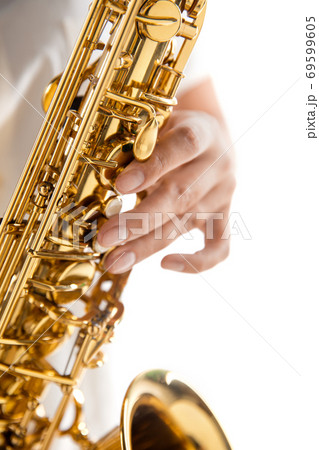 Close up woman playing saxophone isolated on white studio background 69599605
