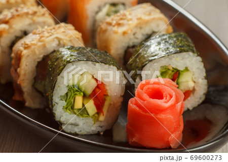 Close up pickled ginger in the form of red rose and sushi rolls 69600273