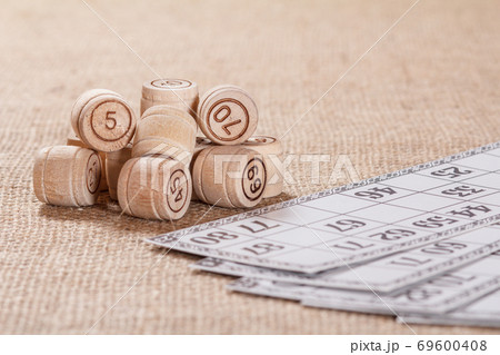 Board game lotto on sackcloth. Wooden lotto barrels and game cards Board game lotto on sackcloth. Wooden lotto barrels and game cards 69600408