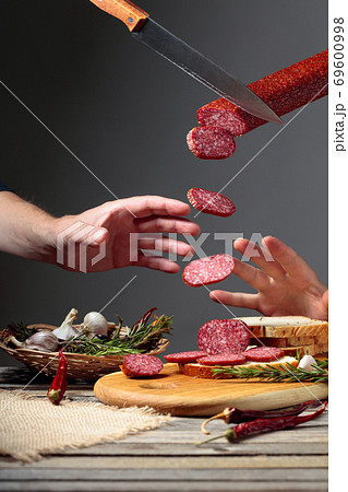 Sandwich with salami on a cutting board. 69600998