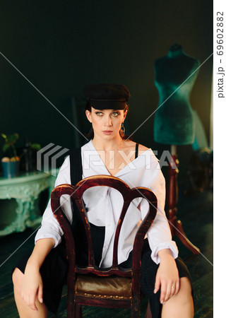 Portrait of a beautiful young woman in a white shirt and black pants in the Studio 69602882