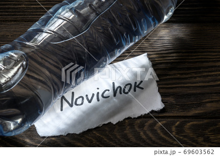 Bottle of water and note Novichok on wooden table close-up. Novichok is agent poison, Bottle of water and note Novichok on wooden table close-up. Novichok is agent poison, 69603562