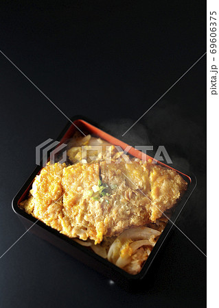 かつ重はトンカツと玉ねぎを煮込み、卵でとじたものをお重に入れ最後に小ねぎを乗せた食べ物です（黒背景） 69606375