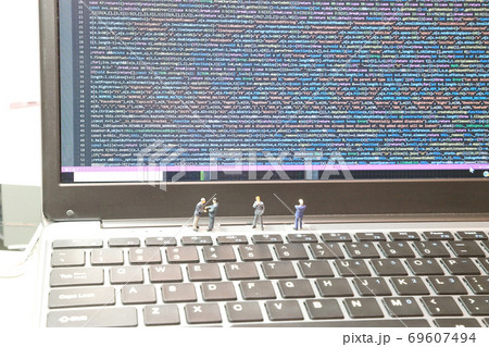 エンジニアイメージのノートpcとビジネスマンのミニチュアの写真素材