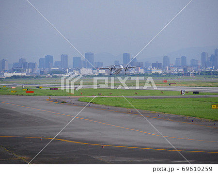大阪国際空港を展望できる公園/下河原緑地よりANAのプロペラ機を見る/遠景に梅田の高層ビル群 大阪国際空港を展望できる公園/下河原緑地よりANAのプロペラ機を見る/遠景に梅田の高層ビル群 69610259