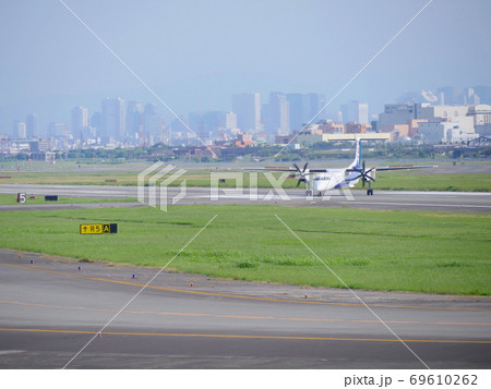 大阪国際空港を展望できる公園/下河原緑地よりANAのプロペラ機を見る/遠景に梅田の高層ビル群 大阪国際空港を展望できる公園/下河原緑地よりANAのプロペラ機を見る/遠景に梅田の高層ビル群 69610262