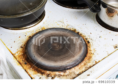 Dirty electric stove close up, house cleaning Dirty electric stove close up, house cleaning 69610339