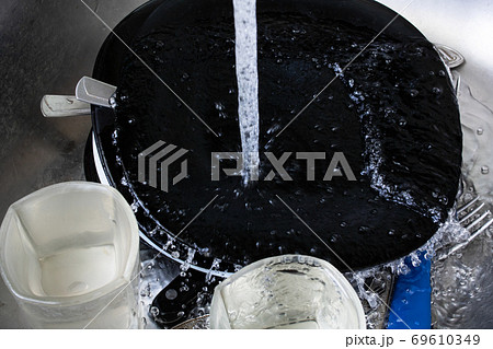 Black dishes and glasses underwater in sink 69610349