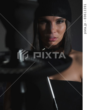 Brunette smoking hookah in dark room Brunette smoking hookah in dark room 69613391