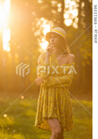 Blond woman resting in forest at sunset 69613396