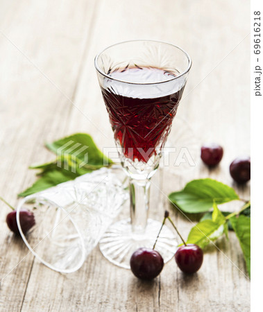 Cherry liqueur in a glass and fresh fruits Cherry liqueur in a glass and fresh fruits 69616218
