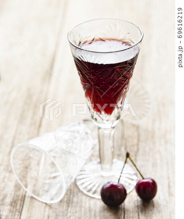 Cherry liqueur in a glass and fresh fruits Cherry liqueur in a glass and fresh fruits 69616219