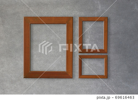 Empty wooden frame on gray cement wall background. 69616463